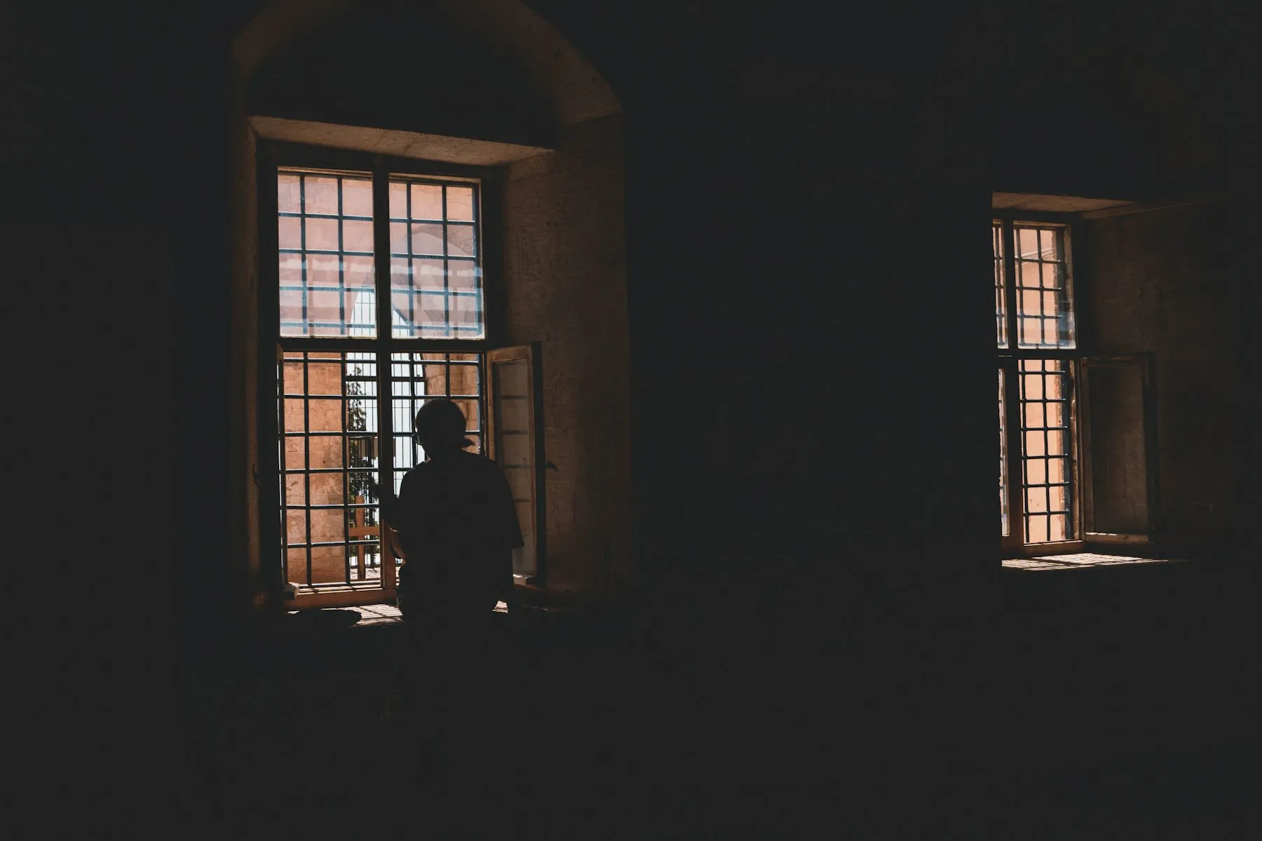 Silueta de una persona mirando por la ventana de noche