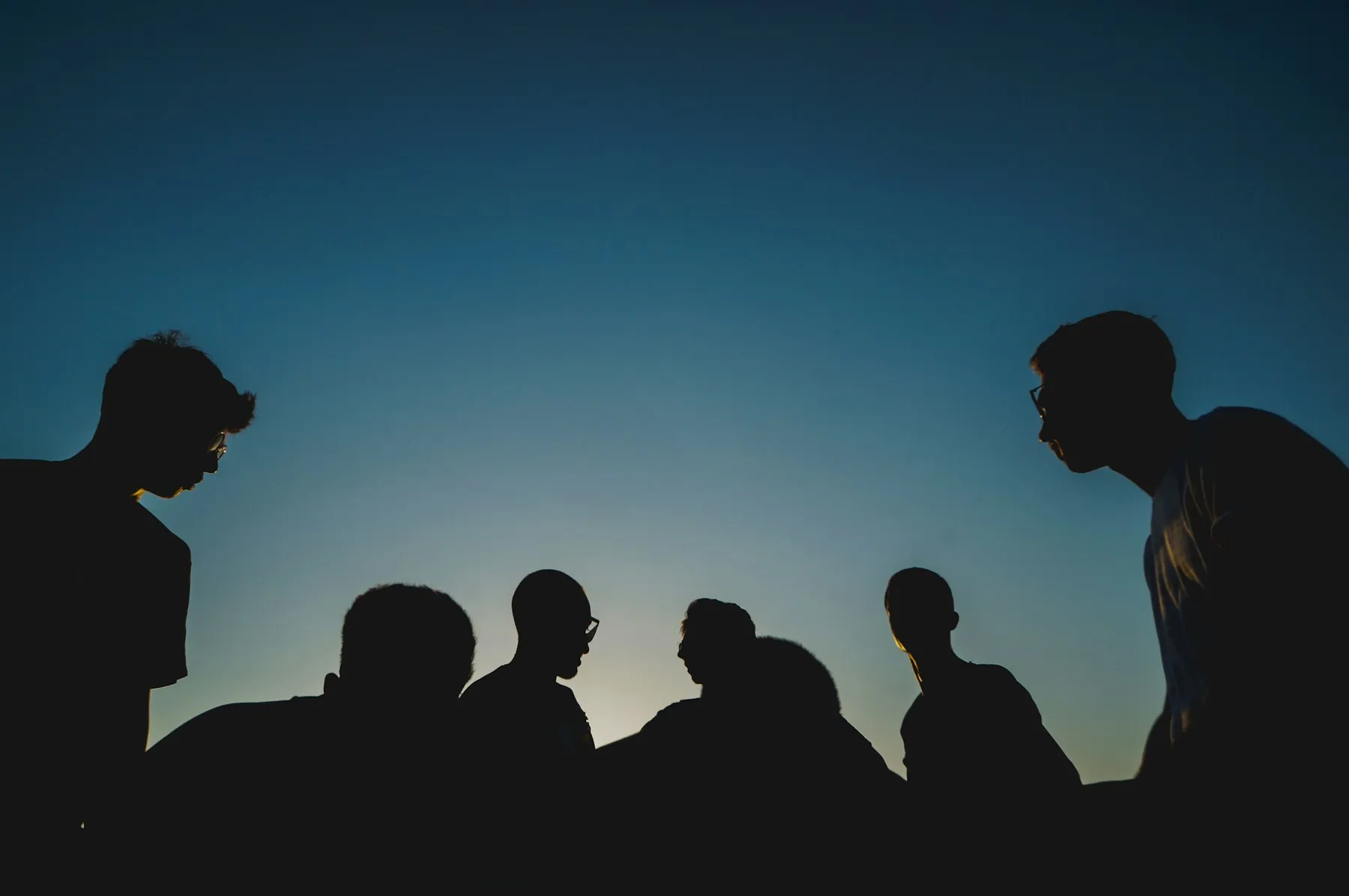 Siluetas de un grupo de jóvenes al anochecer